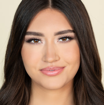 Female model with dark, brown hair wearing Reese Robert Beauty's Faux Fur 2D Feather Effect lashes on light yellow background